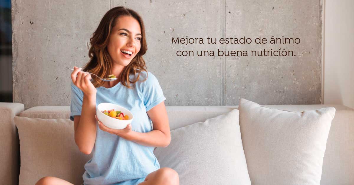 mujer sentada en sillon con bowl con frutas de temporada cortadas en cuadros